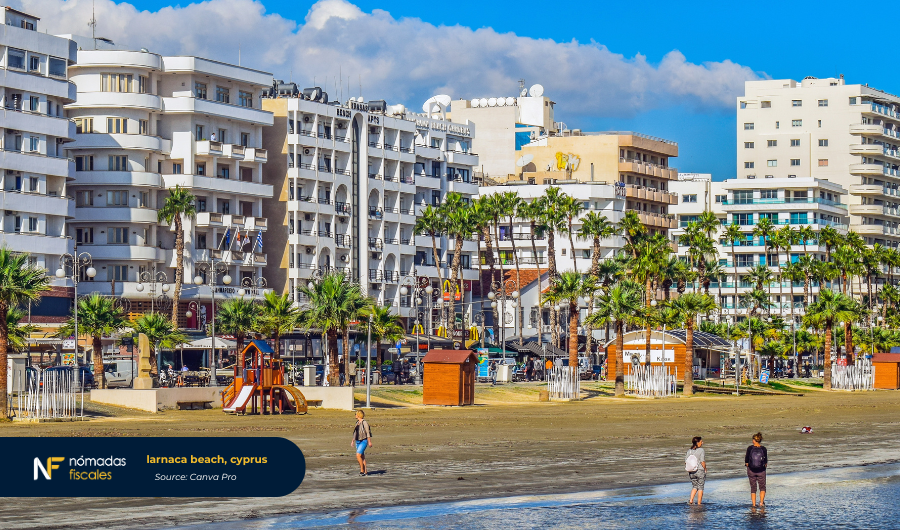 Larnaca Beach in Cyprus with golden sand, palm trees, and clear blue water. A scenic view reflecting the relaxed lifestyle for non-dom tax residents.