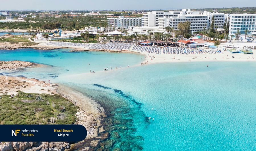 Vista aérea de una playa con aguas turquesa y hoteles en Chipre, destino fiscal favorable para criptomonedas