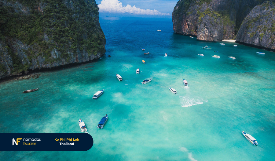 Aerial view of Maya Bay in Thailand, one of the most stunning beaches in the world with crystal-clear waters and boats floating.
